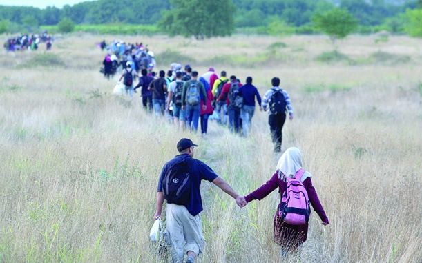Migrants pass through the border from Greece into Macedonia. Photo by AFP